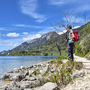 Wanderin mit Rucksack am Wolfgangseeufer in malerischer Berglandschaft.