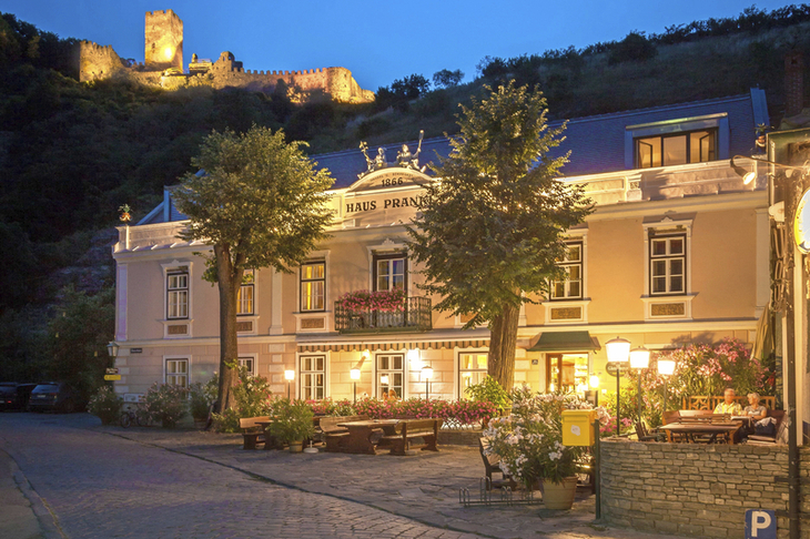 Gasthof Prankl in abendlicher Stimmung mit Burgruine im Hintergrund