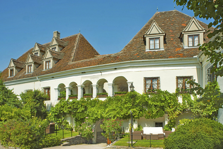 Außenansicht des Reffelsbergerhofs in Weißenkirchen umgeben von grünen Pflanzen.