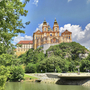 Kloster Stift Melk auf einem Hügel, umgeben von grüner Landschaft und klarem Himmel.