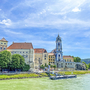 Stift Dürnstein mit blauem Kirchturm am Donauufer bei sonnigem Wetter.