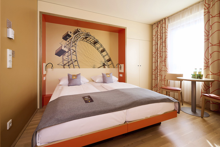 Doppelzimmer im JUFA Hotel Wien City mit modernem Dekor und großem Wandbild.
