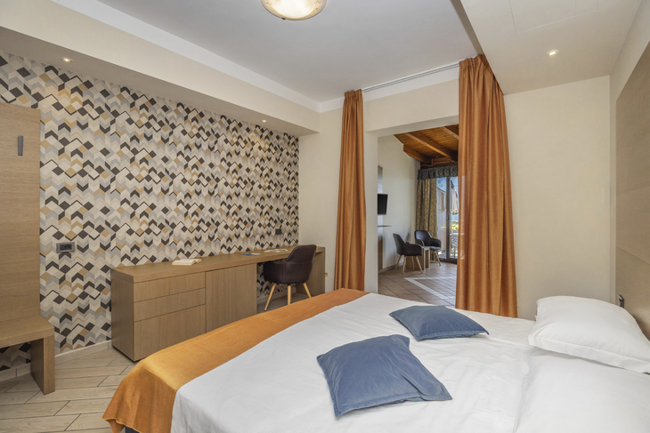 Zimmer in einem Hotel mit Doppelbett, Schreibtisch und Balkonansicht