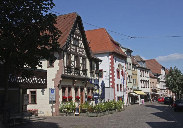 Straße in Karlstadt mit historischen Fachwerkhäusern bei klarem Himmel.