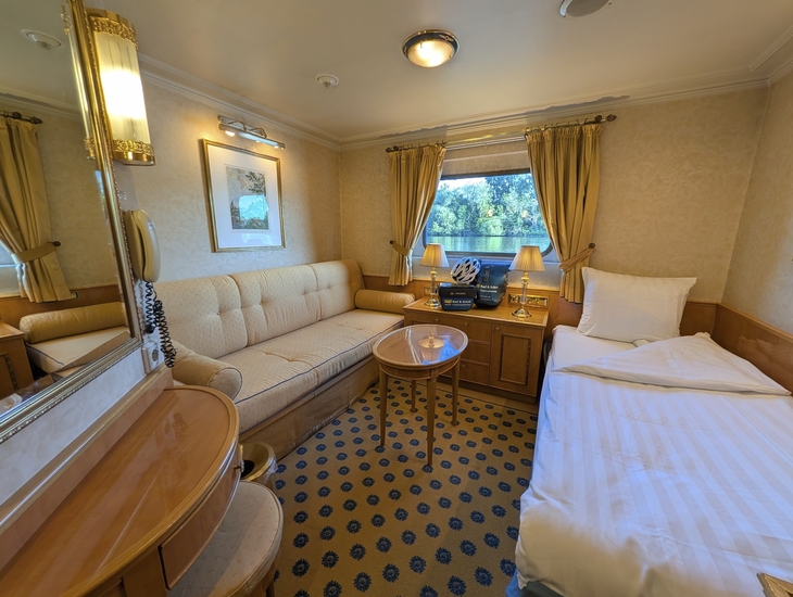 Kabine auf dem Schiff MS Casanova mit Bett, Sofa und Fenster.