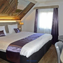 Hotelzimmer mit Doppelbett, Schreibtisch und Fenster, moderne Einrichtung.