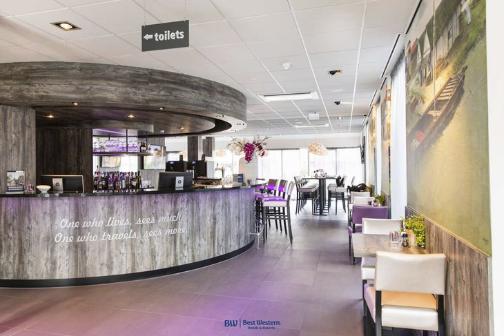 Innenansicht der Lobby eines modernen Hotels mit Bar und Sitzbereichen.