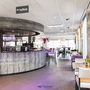 Innenansicht der Lobby eines modernen Hotels mit Bar und Sitzbereichen.