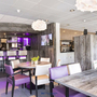 Innenansicht einer modernen Hotelbar mit stilvoller Einrichtung und lila Akzenten.