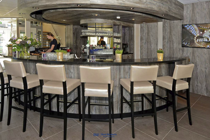Hotelbar mit Theke, Barhockern und Bartender im Best Western City Hotel in Woerden.