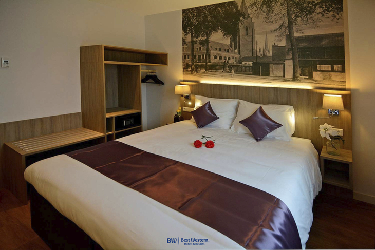 Hotelzimmer mit Doppelbett, Wandbild und stilvoller Dekoration.