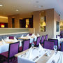 Elegantes Restaurant mit gedeckten Tischen und lila Stühlen im Welcome Hotel Paderborn.