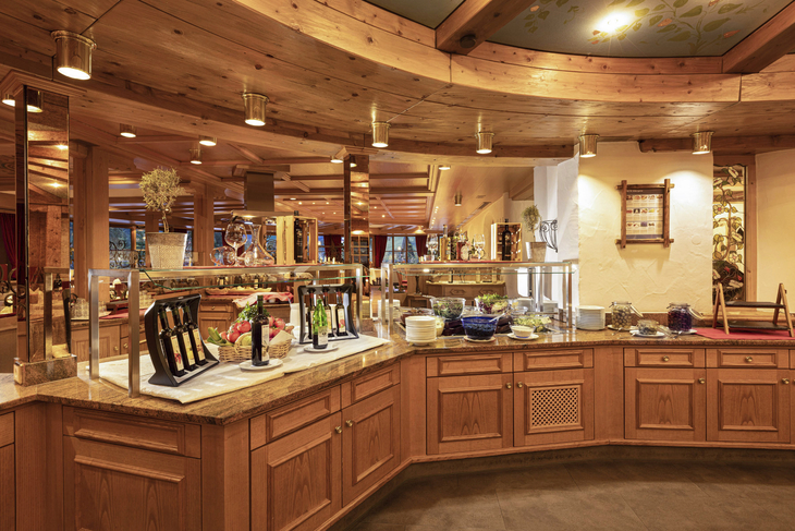 Restaurantbuffet mit warmem Holzdekor und verschiedenen Speisen.