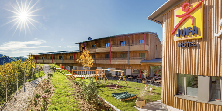 Außenansicht des JUFA Hotels Annaberg bei sonnigem Wetter im Sommer.