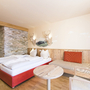 Doppelzimmer mit Doppelbett und Sitzgelegenheit im JUFA Hotel Annaberg.